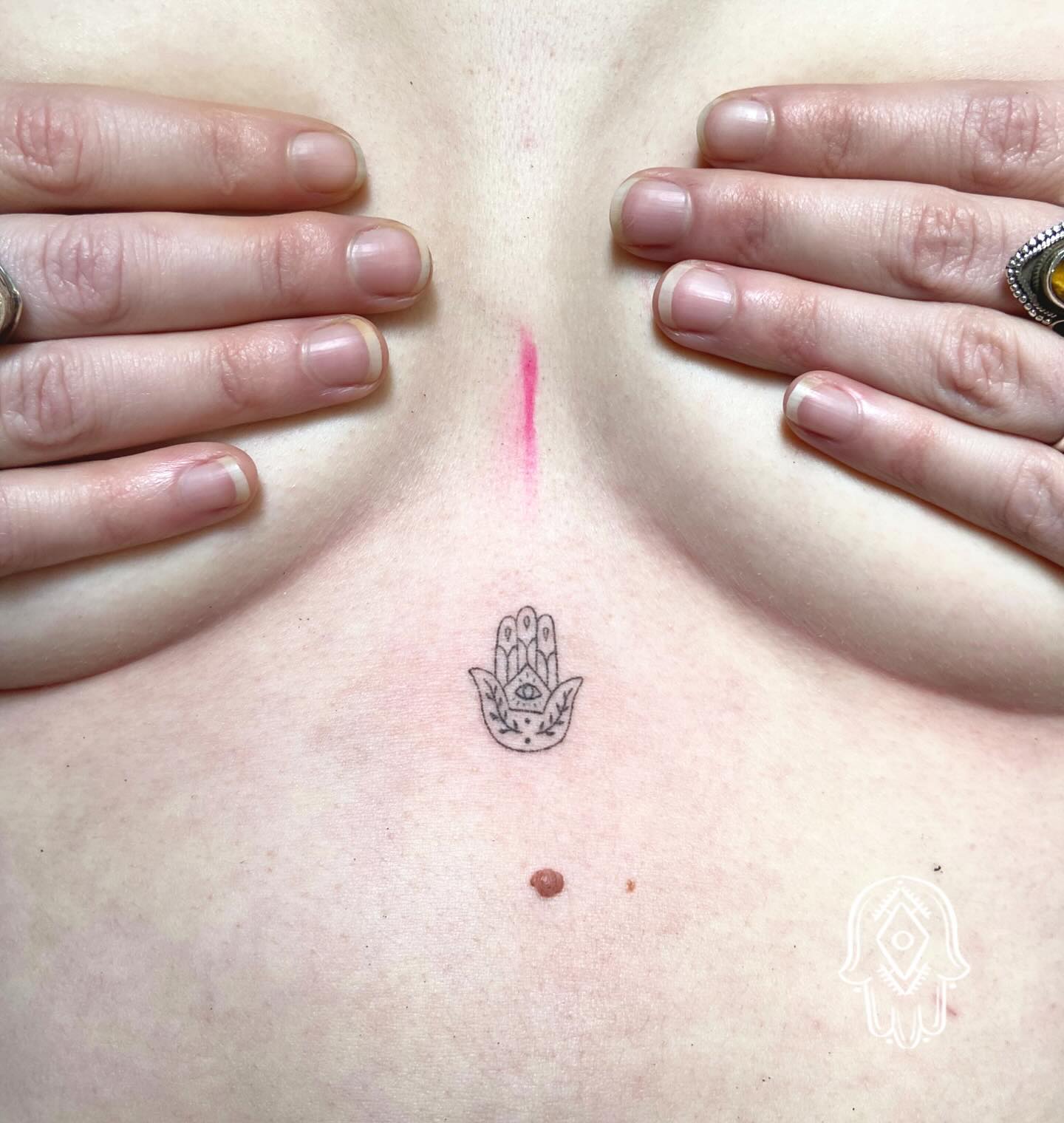 Tatouage Hamsa sternum femme handpoke — symbole de protection précis